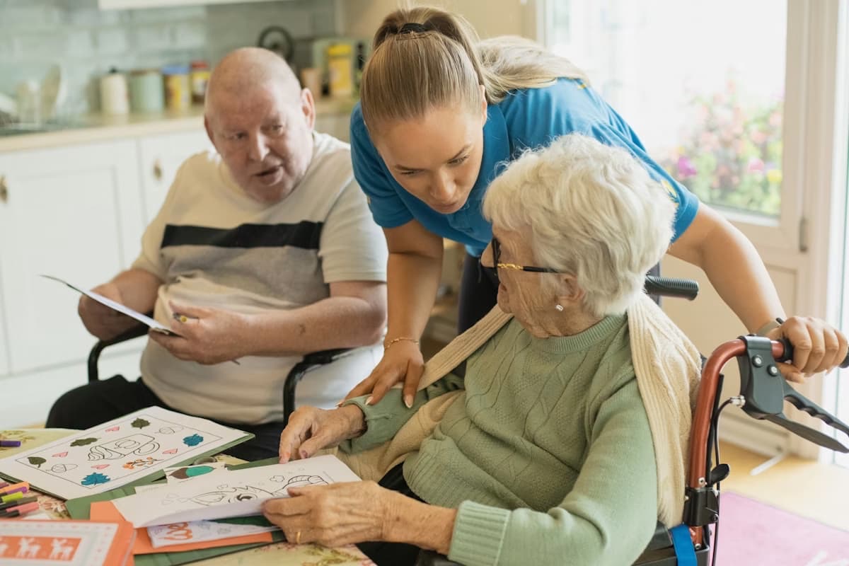 A support worker talking through questions with two people at home